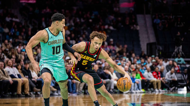 Nov 30, 2024; Charlotte, North Carolina, USA; Atlanta Hawks guard Dyson Daniels (5) controls the ball against Charlotte Hornets guard Josh Green (10) during the second quarter at Spectrum Center. Mandatory Credit: Scott Kinser-Imagn Images