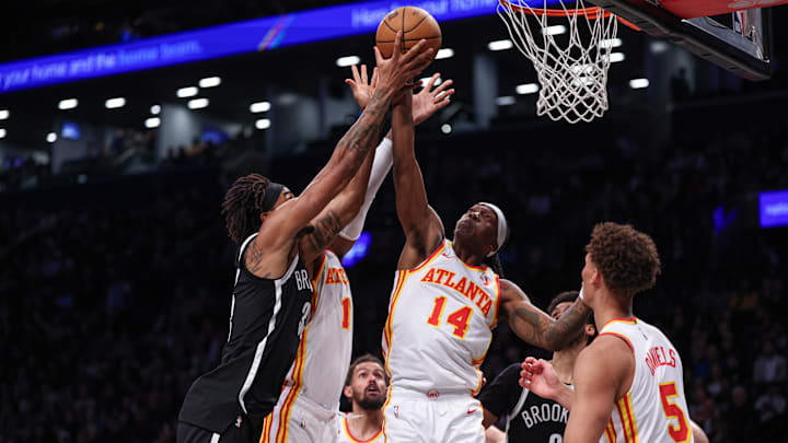 Mar 16, 2025; Brooklyn, New York, USA; Brooklyn Nets center Nic Claxton (33) battles for a rebound against Atlanta Hawks forward Onyeka Okongwu (17) and guard Terance Mann (14) during the second half at Barclays Center. Mandatory Credit: Vincent Carchietta-Imagn Images