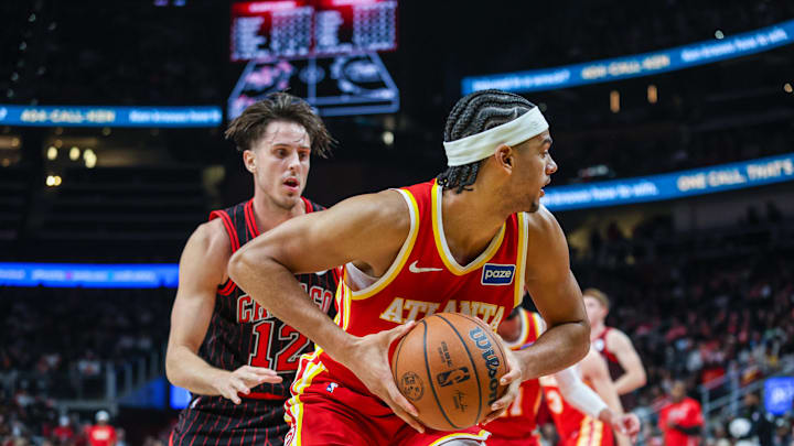 Dec 23, 2025; Atlanta, Georgia, USA; Atlanta Hawks forward Asa Newell (14) grabs the rebound against Chicago Bulls forward Zach Collins (12) during the third quarter at State Farm Arena. Mandatory Credit: Jordan Godfree-Imagn Images