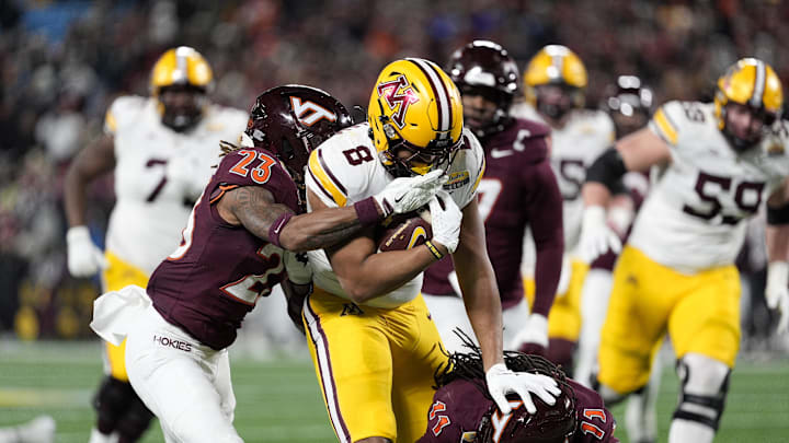 Jan 3, 2025; Charlotte, NC, USA;  Minnesota Golden Gophers running back Jaren Mangham (8) runs for yardage chased by Virginia Tech Hokies cornerback Thomas Williams (23) during the second quarter at the Duke’s Mayo Bowl at Bank of America Stadium. Mandatory Credit: Jim Dedmon-Imagn Images