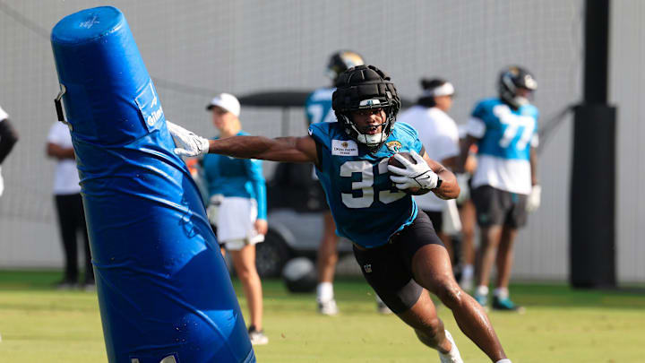 Jacksonville Jaguars running back Bhayshul Tuten (33) runs past a pop-up dummy during an NFL training camp session at the Miller Electric Center, Friday, July 25, 2025, in Jacksonville, Fla. [Corey Perrine/Florida Times-Union]