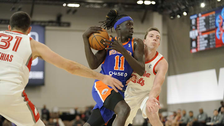 Dec 20, 2022; Las Vegas, NV, USA; Westchester Knicks forward Nuni Omot (11) drives the ball against Memphis Hustle guard Dakota Mathias (31) and forward Justin Bean (34) during the second half at Mandalay Bay Convention Center. Mandatory Credit: Lucas Peltier-Imagn Images