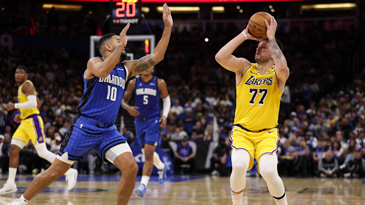 Mar 24, 2025; Orlando, Florida, USA; Los Angeles Lakers guard Luka Doncic (77) shoots the ball over Orlando Magic guard Cory Joseph (10) in the second quarter at Kia Center. Mandatory Credit: Nathan Ray Seebeck-Imagn Images