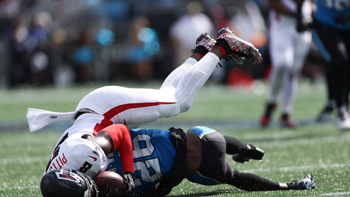 Sep 21, 2025; Charlotte, North Carolina, USA; Atlanta Falcons tight end Kyle Pitts (8) gets tackled by Carolina Panthers cornerback Chau Smith-Wade (26) during the second half of a game at Bank of America Stadium. 