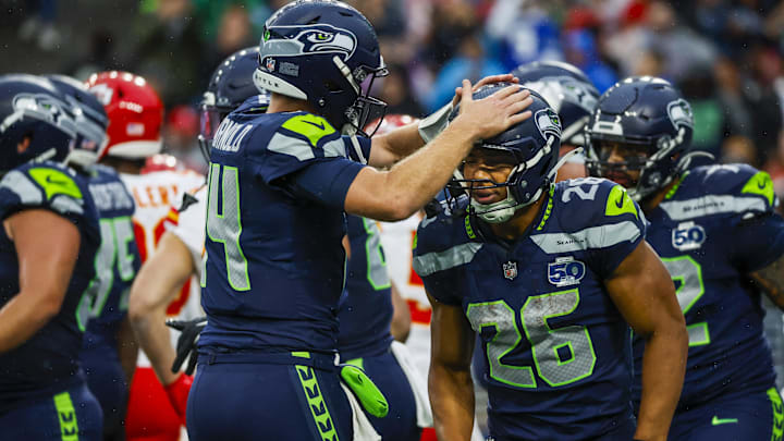 Aug 15, 2025; Seattle, Washington, USA; Seattle Seahawks running back Zach Charbonnet (26) celebrates with quarterback Sam Darnold (14) after rushing for a touchdown against the Kansas City Chiefs during the first quarter at Lumen Field. Mandatory Credit: Joe Nicholson-Imagn Images