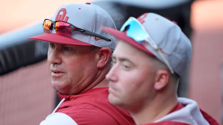 Oklahoma coach Skip Johnson sits in the dugout 