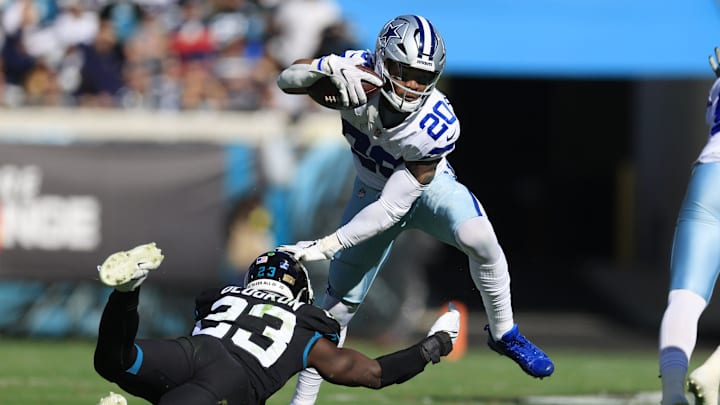 Dallas Cowboys running back Tony Pollard (20) fends off Jacksonville Jaguars linebacker Foyesade
