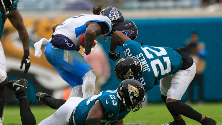 Tennessee Titans running back Tyjae Spears lose his guardian cap to Jacksonville Jaguars cornerback Jarrian Jones.