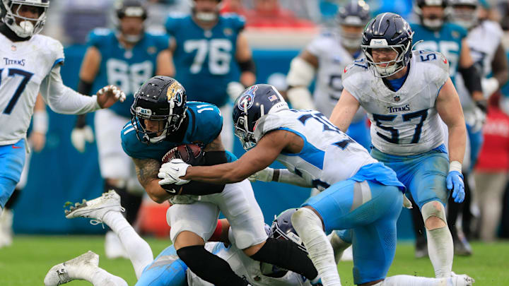 Jacksonville Jaguars wide receiver Parker Washington rushes for yards against Tennessee Titans safety Mike Brown. Jacksonville Jaguars wide receiver Parker Washington rushes for yards against Tennessee Titans safety Mike Brown.