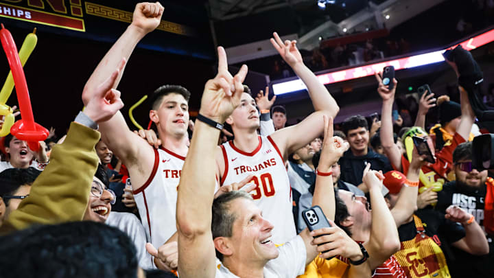Feb 1, 2025; Los Angeles, California, USA;  USC Trojans players celebrate with fans in the student section after defeating the Michigan State Spartans at Galen Center. Mandatory Credit: William Navarro-Imagn Images