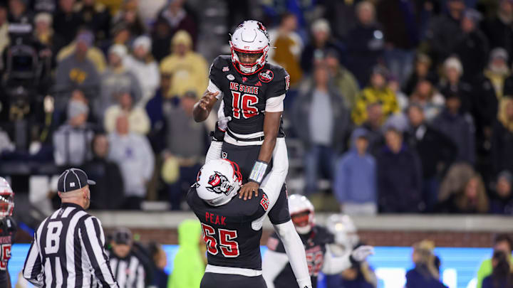 Nov 21, 2024; Atlanta, Georgia, USA; North Carolina State Wolfpack quarterback Brody Rhodes (16) celebrates after scoring a two-point conversion with offensive tackle Jacarrius Peak (65) against the Georgia Tech Yellow Jackets in the fourth quarter at Bobby Dodd Stadium at Hyundai Field. Mandatory Credit: Brett Davis-Imagn Images