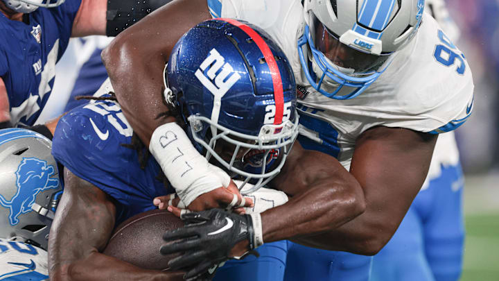 Aug 8, 2024; East Rutherford, New Jersey, USA; New York Giants running back Dante Miller (25) is tackled by Detroit Lions defensive tackle Brodric Martin (99) during the second half at MetLife Stadium. Mandatory Credit: Vincent Carchietta-Imagn Images Aug 8, 2024; East Rutherford, New Jersey, USA; New York Giants running back Dante Miller (25) is tackled by Detroit Lions defensive tackle Brodric Martin (99) during the second half at MetLife Stadium. Mandatory Credit: Vincent Carchietta-Imagn Images