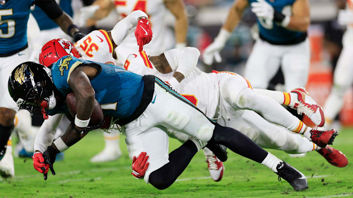 Jacksonville Jaguars running back Travis Etienne (1) is tackled by Kansas City Chiefs cornerback Jaylen Watson (35) and safety Bryan Cook (6) during the second quarter of an NFL football matchup at EverBank Stadium, Monday, Oct. 6, 2025, in Jacksonville, Fla. [Corey Perrine/Florida Times-Union]