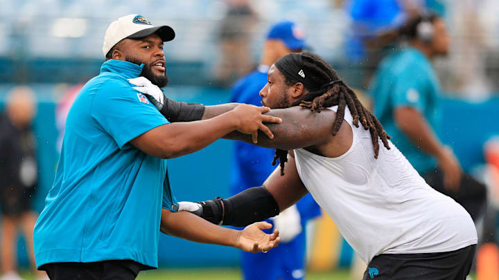 Jeremy Garrett works with defensive tackle DaVon Hamilton during warmups prior to a Jacksonville game with the Colts.