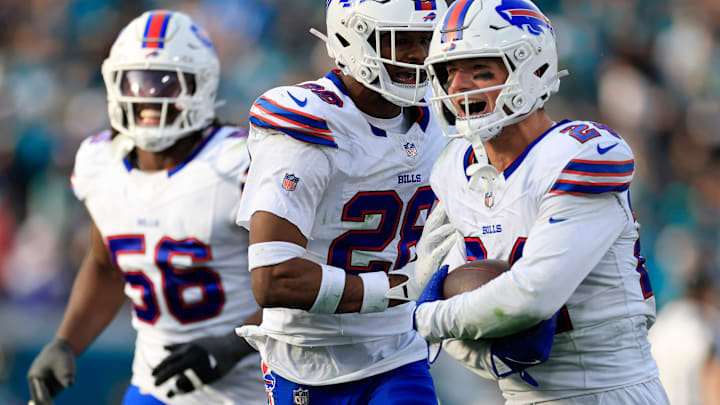 Buffalo Bills safety Sam Franklin Jr. (28), center, celebrates safety Cole Bishop (24), right, for grabbing a game-sealing interception, as defensive end Javon Solomon (56) looks on.