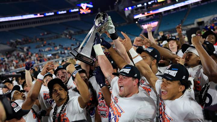 Virginia Cavaliers center Drake Metcalf (60), center, and other players, hold up the Ash Verlander Champions Trophy after the game of the TaxSlayer Gator Bowl at EverBank Stadium, Saturday, Dec. 27, 2025, in Jacksonville. Fla. Virginia defeated Missouri 13-7. Virginia Cavaliers center Drake Metcalf (60), center, and other players, hold up the Ash Verlander Champions Trophy after the game of the TaxSlayer Gator Bowl at EverBank Stadium, Saturday, Dec. 27, 2025, in Jacksonville. Fla. Virginia defeated Missouri 13-7.