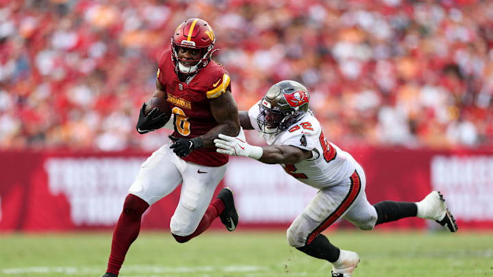 Sep 8, 2024; Tampa, Florida, USA; Washington Commanders running back Brian Robinson Jr. (8) breaks a tackle from Tampa Bay Buccaneers linebacker K.J. Britt (52) in the third quarter at Raymond James Stadium. Mandatory Credit: Nathan Ray Seebeck-Imagn Images