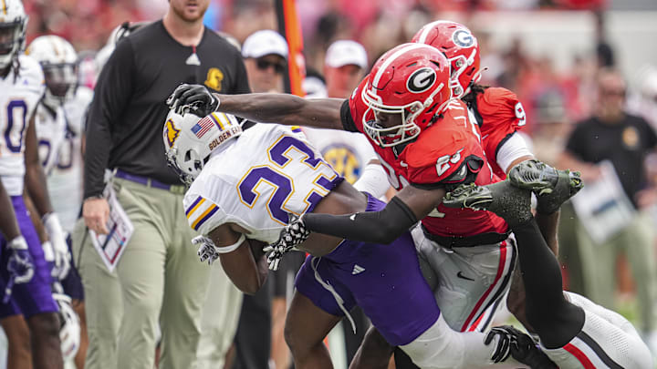 Sep 7, 2024; Athens, Georgia, USA; Tennessee Tech Golden Eagles running back Obie Sanni (23) is tackled by Georgia Bulldogs defensive back JaCorey Thomas (20) and defensive back Julian Humphrey (12) during the second half at Sanford Stadium. Mandatory Credit: Dale Zanine-Imagn Images