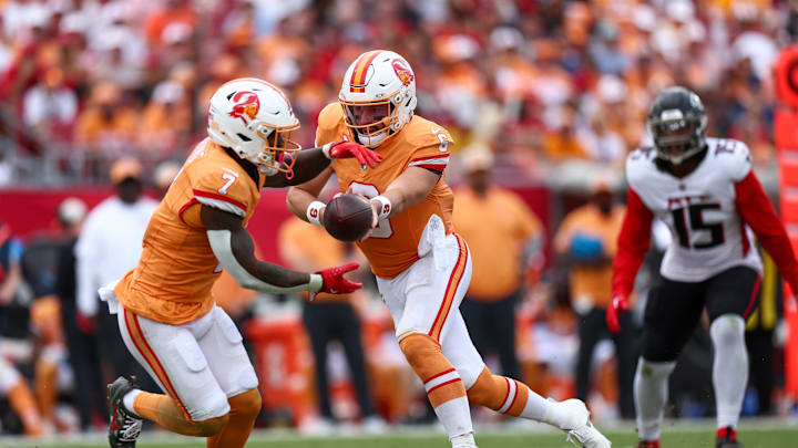 Oct 27, 2024; Tampa, Florida, USA; Tampa Bay Buccaneers quarterback Baker Mayfield (6) hands off to running back Bucky Irving (7) against the Atlanta Falcons in the third quarter at Raymond James Stadium. Mandatory Credit: Nathan Ray Seebeck-Imagn Images