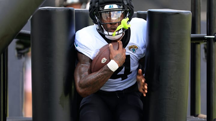 Jacksonville Jaguars running back Tank Bigsby (4) runs through a powerblast machine during an NFL training camp session at the Miller Electric Center, Thursday, Aug. 14, 2025 in Jacksonville, Fla.