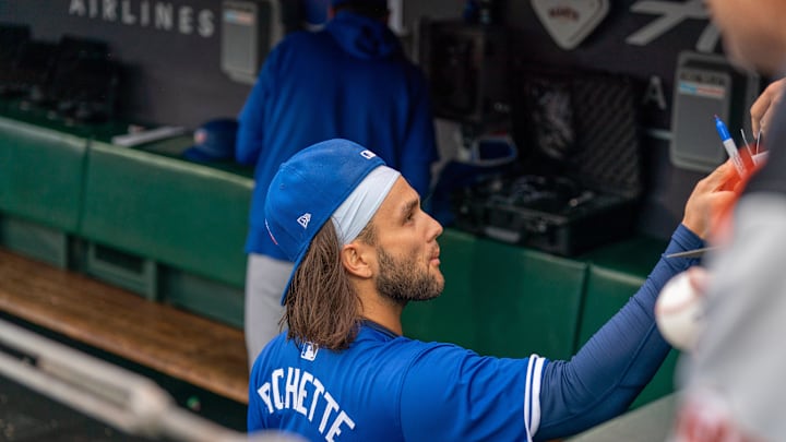 Toronto Blue Jays shortstop Bo Bichette (11) autographs baseballs for fans before the start of the game against the San Francisco Giants at Oracle Park on July 9.