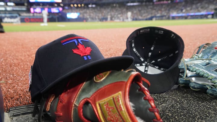 A Toronto Blue Jays hat and glove near the dugout during a game against the Detroit Tigers at Rogers Centre.