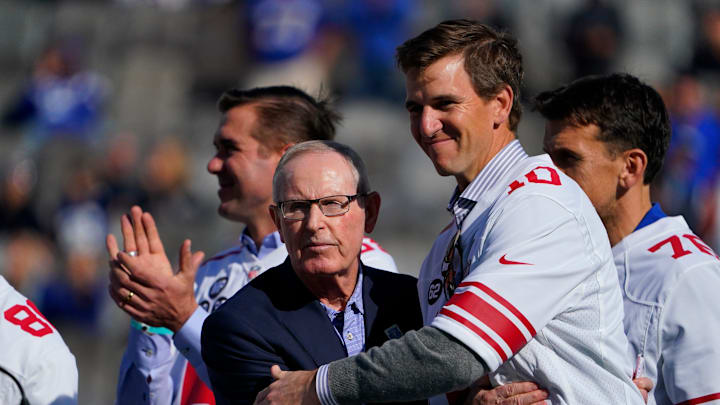 Oct 17, 2021; East Rutherford, NJ, USA;  New York Giants former head coach Tom Coughlin and quarterback Eli Manning hug during the ceremony honoring the Super Bowl XLVI winning team.  