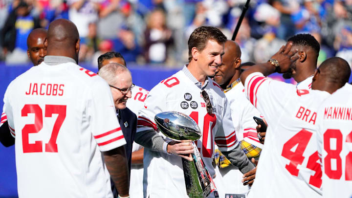 Oct 17, 2021; East Rutherford, NJ, USA; New York Giants former quarterback Eli Manning and head coach Tom Coughlin walk onto the field with the Vince Lombardi Trophy for a ceremony marking the 10 year anniversary of their Super Bowl win in 2011.
