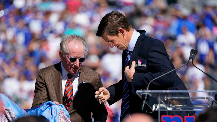 New York Giants' Eli Manning puts on the Ring of Honor jacket as his father Archie Manning looks on during the ceremony at MetLife Stadium on Sunday, Sept. 26, 2021, in East Rutherford. 