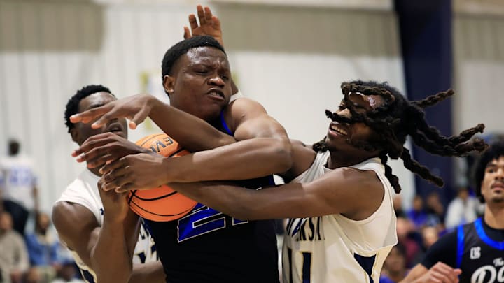 Impact Christian's Mechack Olungu (21) is guarded by University Christian Augustine Ayelyine (13), left, and Dexter Clark Jr. (11) during the second quarter of a high school basketball matchup Friday, Jan. 31, 2025 at University Christian School in Jacksonville, Fla. The University Christian Fighting Christians defeated the Impact Christian Lions 71-54. [Corey Perrine/Florida Times-Union]