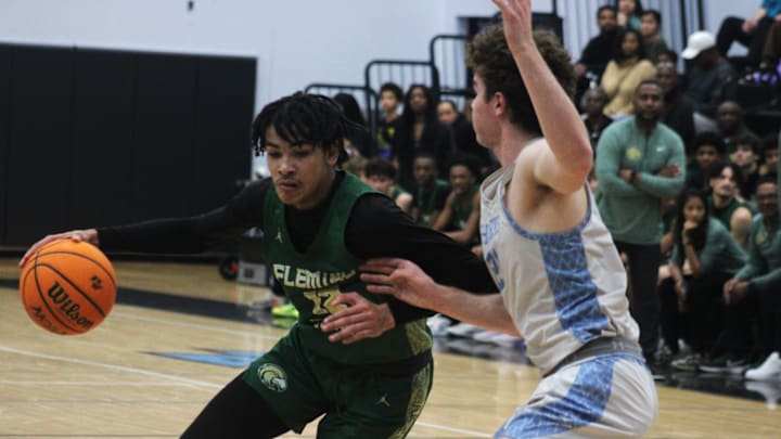 Fleming Island forward Carson Crawford (12) dribbles into the lane as Ponte Vedra forward Tyler Cowan (21) defends during an FHSAA District 3-6A high school boys basketball semifinal on February 8, 2024. [Clayton Freeman/Florida Times-Union]