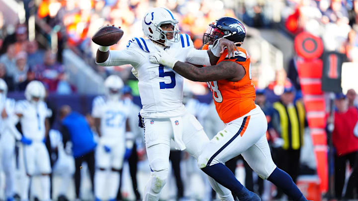 Dec 15, 2024; Denver, Colorado, USA; Denver Broncos defensive end John Franklin-Myers (98) grabs onto Indianapolis Colts quarterback Anthony Richardson (5) in the second quarter at Empower Field at Mile High. Mandatory Credit: Ron Chenoy-Imagn Images