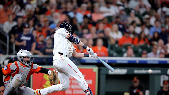 A baseball player in a white uniform and black helmet swinging a white baseball bat A baseball player in a white uniform and black helmet swinging a white baseball bat