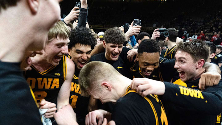 Iowa’s Cooper Koch (8), Kael Combs (11), Trey Thompson (20), Cam Manyawu (3) and Brendan Hausen (15) mob Bennett Stirtz (14) after the Hawkeyes defeated the Nebraska Cornhuskers 57-52 Feb. 17, 2026 at Carver-Hawkeye Arena in Iowa City, Iowa.