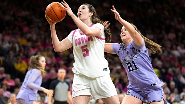 Iowa center Ava Heiden (5) looks to score against Washington forward Brynn McGaughy (21) Feb. 11, 2026 at Carver-Hawkeye Arena in Iowa City, Iowa.