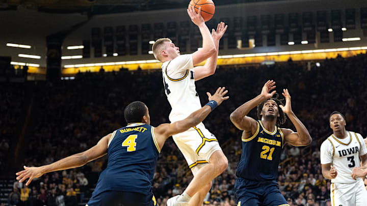 Iowa guard Bennett Stirtz (14) shoots the basketball as Michigan guard Nimari Burnett (4) and Michigan forward Morez Johnson Jr. (21) defend March 5, 2026 during a Big Ten basketball game at Carver-Hawkeye Arena in Iowa City, Iowa.