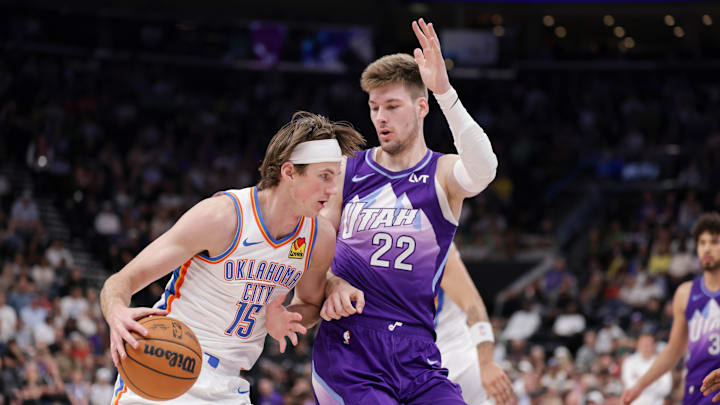 Apr 11, 2025; Salt Lake City, Utah, USA;  Oklahoma City Thunder center Branden Carlson (15) tries to dribble past Utah Jazz forward Kyle Filipowski (22) during the second quarter at Delta Center. Mandatory Credit: Chris Nicoll-Imagn Images