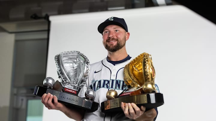 Seattle Mariners catcher Cal Raleigh poses for a portrait with his Rawlings Gold Glove and Platinum Glove trophies during media day at Peoria Sports Complex on Feb. 20.