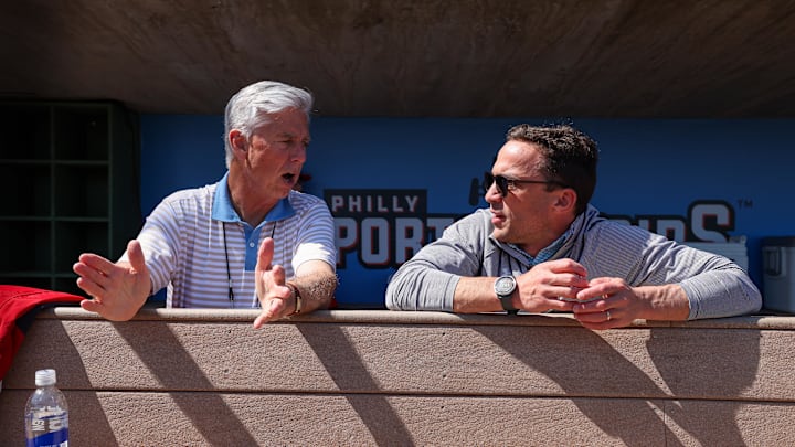 Feb 25, 2024; Clearwater, Florida, USA;  Philadelphia Phillies president of baseball operations Dave Dombrowski and general manager Sam Fuld talk in the dugout before a game against the New York Yankees at BayCare Ballpark. Mandatory Credit: Nathan Ray Seebeck-Imagn Images