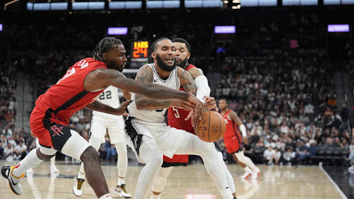 Oct 26, 2024; San Antonio, Texas, USA;  San Antonio Spurs forward Julian Champagnie (30) goes after a ball between Houston Rockets forward Tari Eason (17) and guard Fred VanVleet (5) in the second half at Frost Bank Center. Mandatory Credit: Daniel Dunn-Imagn Images