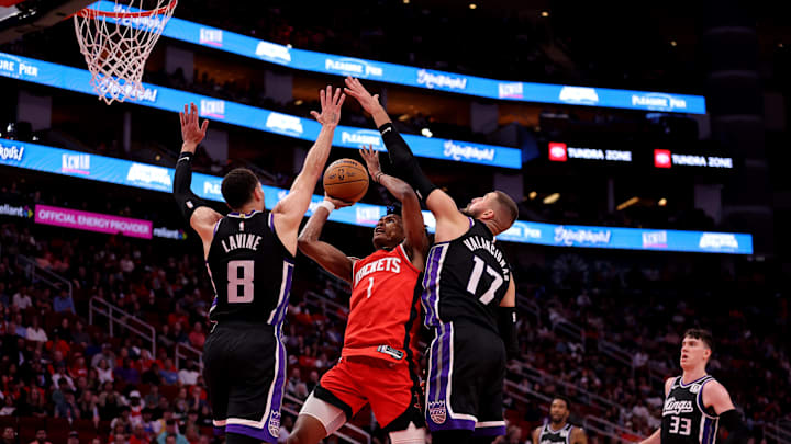 Mar 1, 2025; Houston, Texas, USA; Houston Rockets guard Amen Thompson (1) shoots inside against Sacramento Kings guard Zach LaVine (8) and Sacramento Kings center Jonas Valanciunas (17) during the second quarter at Toyota Center. Mandatory Credit: Erik Williams-Imagn Images