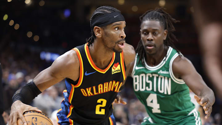Jan 5, 2025; Oklahoma City, Oklahoma, USA; Oklahoma City Thunder guard Shai Gilgeous-Alexander (2) moves the ball around Boston Celtics guard Jrue Holiday (4) during the fourth quarter at Paycom Center. Mandatory Credit: Alonzo Adams-Imagn Images