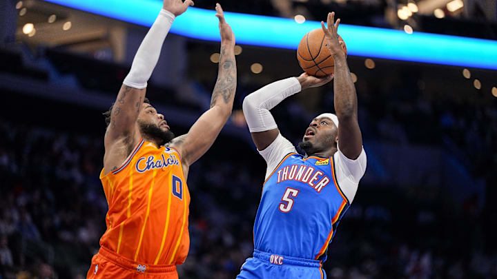 Nov 15, 2025; Charlotte, North Carolina, USA; Oklahoma City Thunder guard Luguentz Dort (5) shoots defended by Charlotte Hornets forward Miles Bridges (0) during the second half at Spectrum Center. Mandatory Credit: Jim Dedmon-Imagn Images