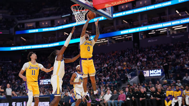 Oct 18, 2024; San Francisco, California, USA; Los Angeles Lakers guard Jalen Hood-Schifino (0) makes a basket in front of Golden State Warriors forward Kevon Looney (5) in the second quarter at the Chase Center. Mandatory Credit: Cary Edmondson-Imagn Images Oct 18, 2024; San Francisco, California, USA; Los Angeles Lakers guard Jalen Hood-Schifino (0) makes a basket in front of Golden State Warriors forward Kevon Looney (5) in the second quarter at the Chase Center. Mandatory Credit: Cary Edmondson-Imagn Images
