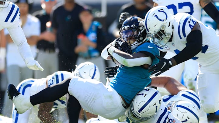 Jacksonville Jaguars running back Travis Etienne Jr. (1) is tackled by Indianapolis Colts defensive tackle DeForest Buckner (99), bottom, and linebacker Zaire Franklin (44) during the fourth quarter of an NFL football matchup Sunday, Oct. 15, 2023 at EverBank Stadium in Jacksonville, Fla. The Jacksonville Jaguars defeated the Indianapolis Colts 37-20. [Corey Perrine/Florida Times-Union]