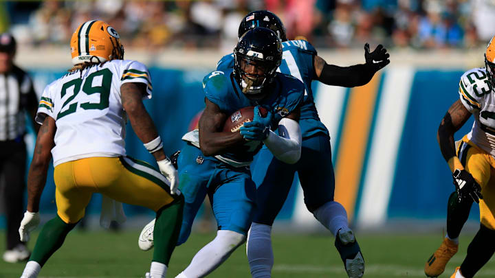 Jacksonville Jaguars running back Tank Bigsby (4) rushes for yards against Green Bay Packers safety Xavier McKinney (29) during the fourth quarter of an NFL football matchup Sunday, Oct. 27, 2024 at EverBank Stadium in Jacksonville, Fla. The Packers edged the Jaguars 30-27 on a last-second field goal. [Corey Perrine/Florida Times-Union]