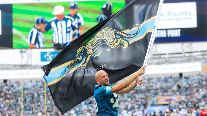 A Jacksonville Jaguars flag bearer waves a vintage throwback flag after a score during the fourth quarter of an NFL football matchup Sunday, Oct. 6, 2024 at EverBank Stadium in Jacksonville, Fla. The Jaguars edged the Colts on a field goal 37-34. [Corey Perrine/Florida Times-Union]