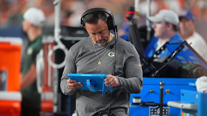 Aug 18, 2024; Denver, Colorado, USA; Green Bay Packers linebackers coach Anthony Campanile looks at a tablet in the second half against the Denver Broncos at Empower Field at Mile High. Mandatory Credit: Ron Chenoy-Imagn Images