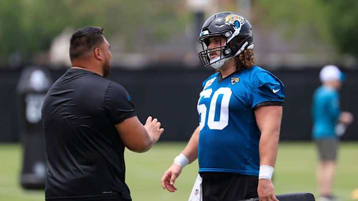Jacksonville Jaguars assistant offensive line/run game specalist Keli'i Kekuewa, left, talks technique with center Jonah Monheim (60) during a rookie minicamp at Miller Electric Center Saturday, May 10, 2025 in Jacksonville, Fla. [Corey Perrine/Florida Times-Union]