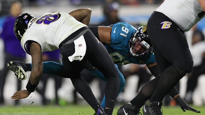 Baltimore Ravens quarterback Lamar Jackson (8) manages to escape Jacksonville Jaguars linebacker Dawuane Smoot (91) during the third quarter of a regular season NFL football matchup Sunday, Dec. 17, 2023 at EverBank Stadium in Jacksonville, Fla. The Baltimore Ravens defeated the Jacksonville Jaguars 23-7. [Corey Perrine/Florida Times-Union]